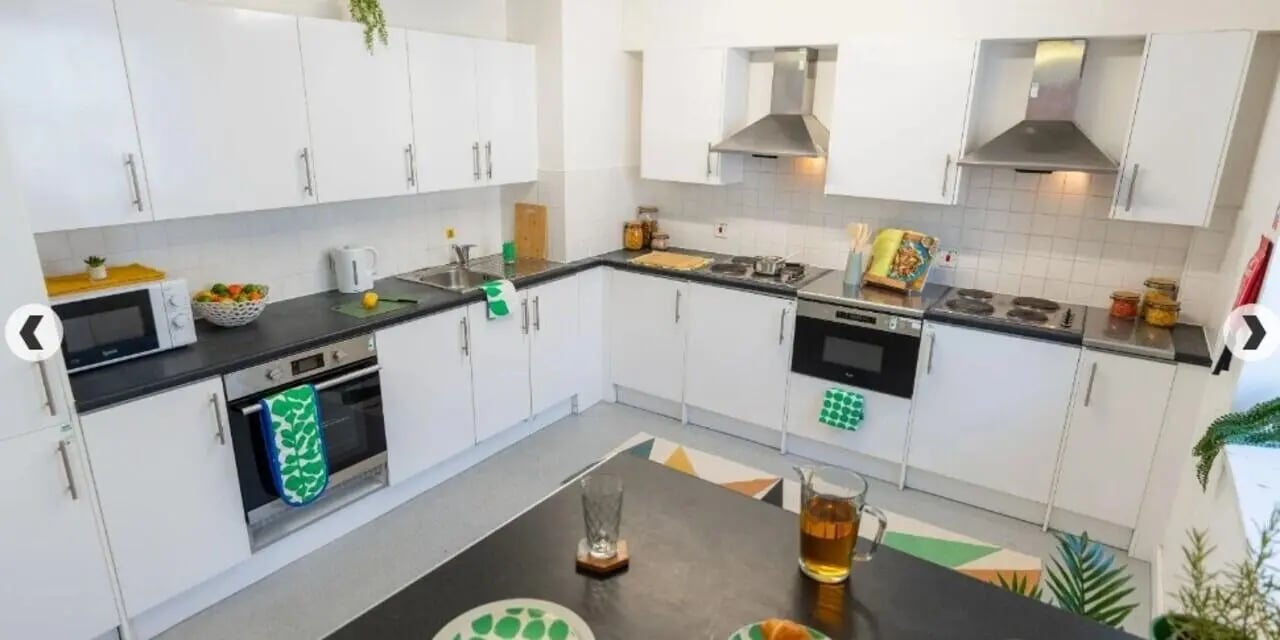 White cabinets microwave oven stove sink kitchen area at The Craft Building in London Student Accommodation
