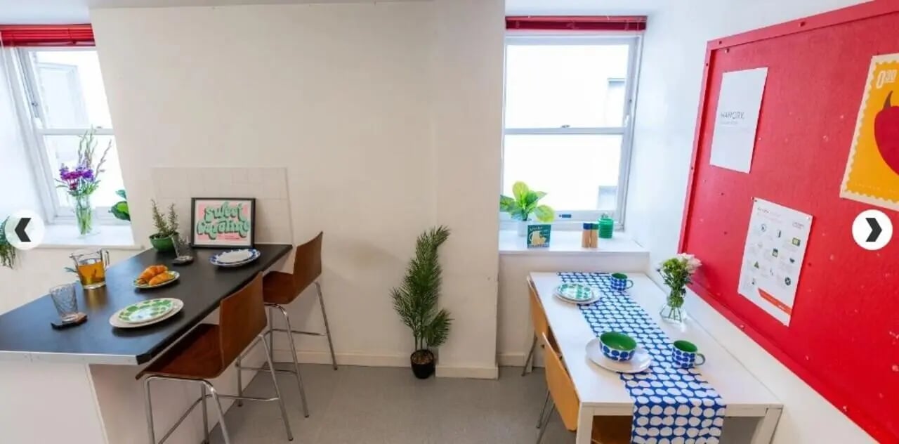 Kitchen area with two tables chairs and plants interior at The Craft Building in London Student Accommodation