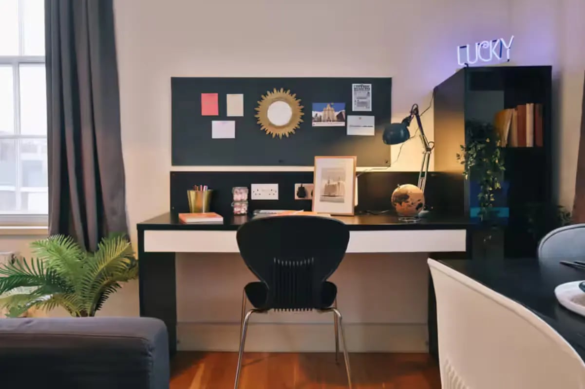 Desk with chair plant and neon sign study area at Art School Lofts in Liverpool Student Accommodation