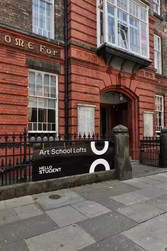 Brick building with arched entryway and signage exterior at Art School Lofts in Liverpool Student Accommodation
