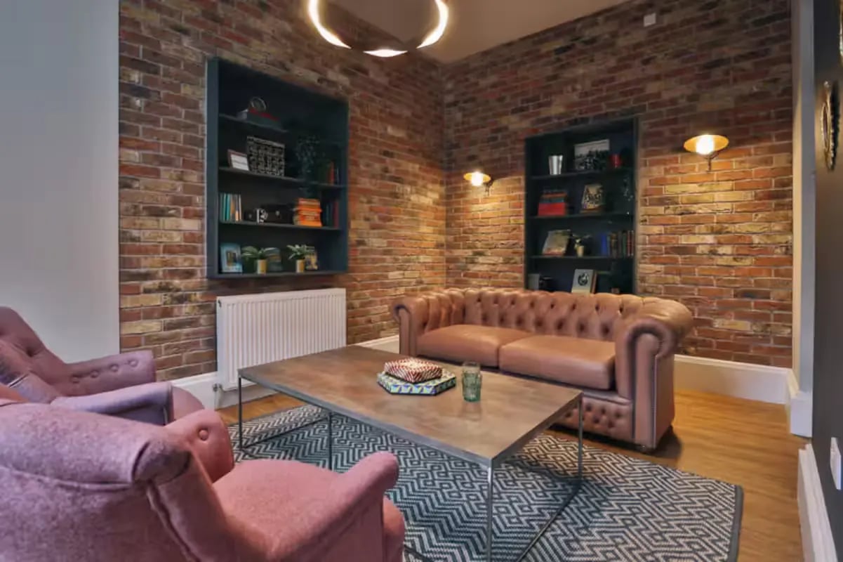 Pink armchairs brown sofa coffee table living room at Art School Lofts in Liverpool Student Accommodation