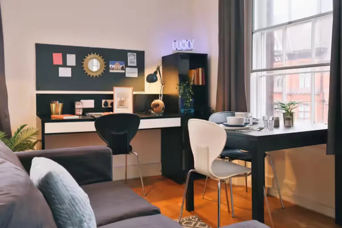 Desk sofa table chairs and window living room at Art School Lofts in Liverpool Student Accommodation