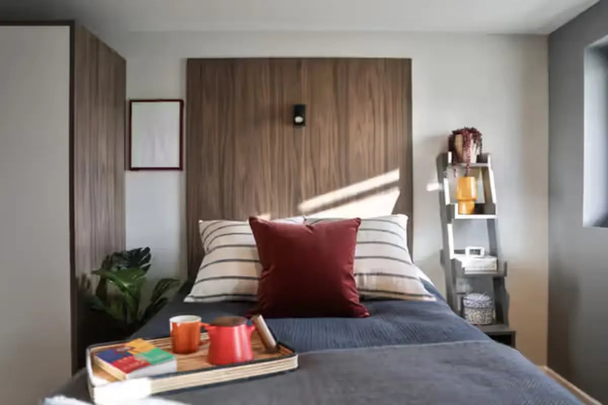 Bed with pillows books and tray bedroom at Art School Lofts in Liverpool Student Accommodation