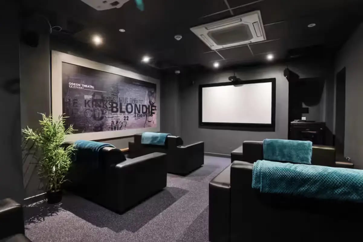 Black leather seating with teal blankets cinema room at Buccleuch Street in Edinburgh Student Accommodation