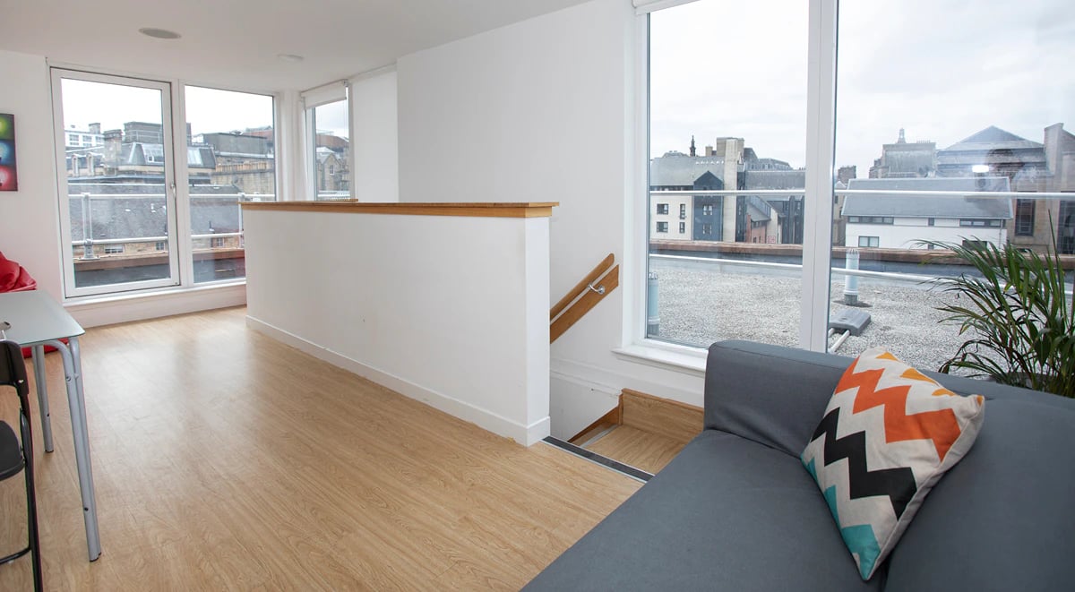 Living area with sofa city view and stairs living area at 200 Cowgate in Edinburgh Student Accommodation