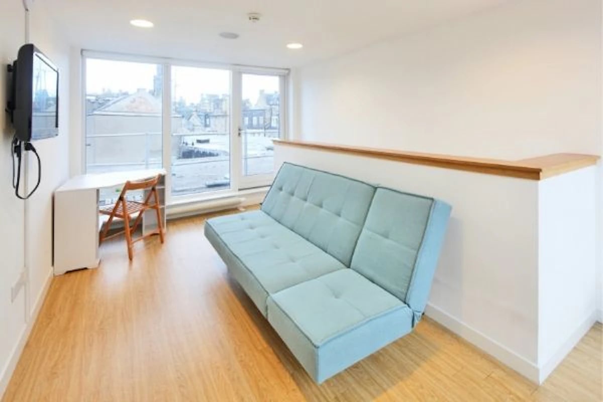 Sofa desk chair television floor living room at 200 Cowgate in Edinburgh Student Accommodation