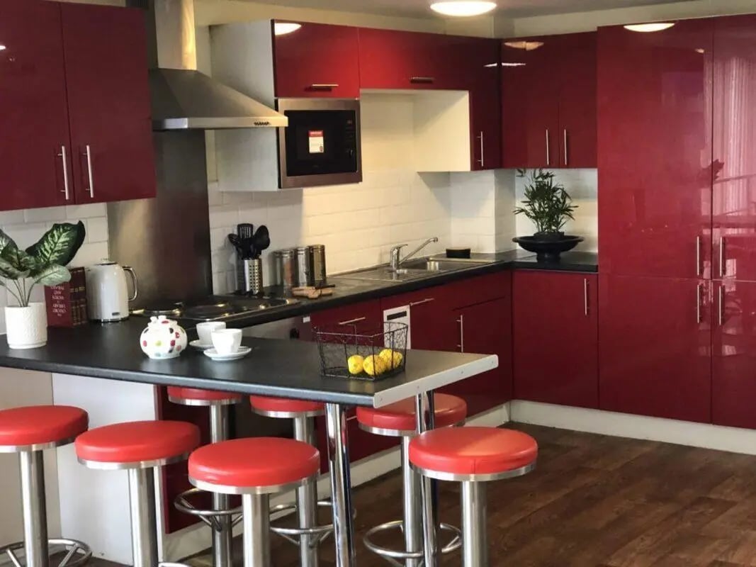Red cabinets microwave stools counter kitchen area at Falkland House in Liverpool Student Accommodation