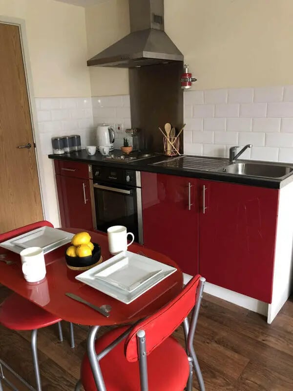 Red table and chairs kitchen with hob sink at Falkland House in Liverpool Student Accommodation