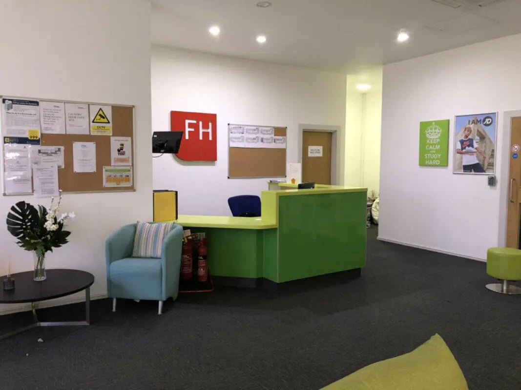 Reception desk fire extinguishers chair and coffee table reception area at Falkland House in Liverpool Student Accommodation