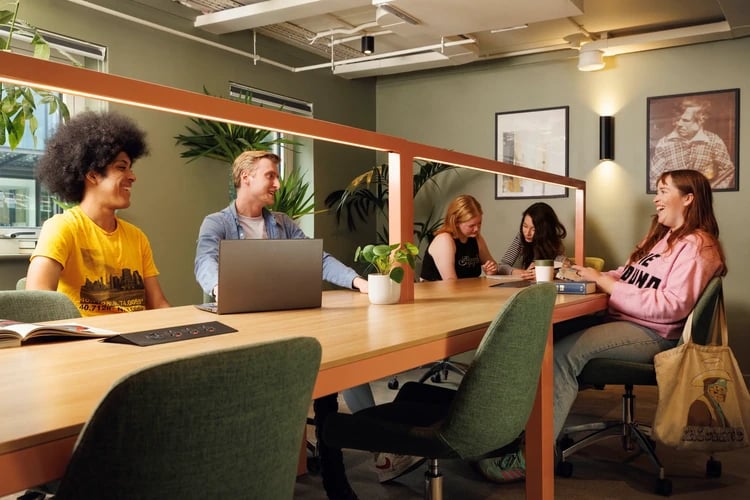 Students at a communal table with laptops study area at The Bridge House in Edinburgh Student Accommodation