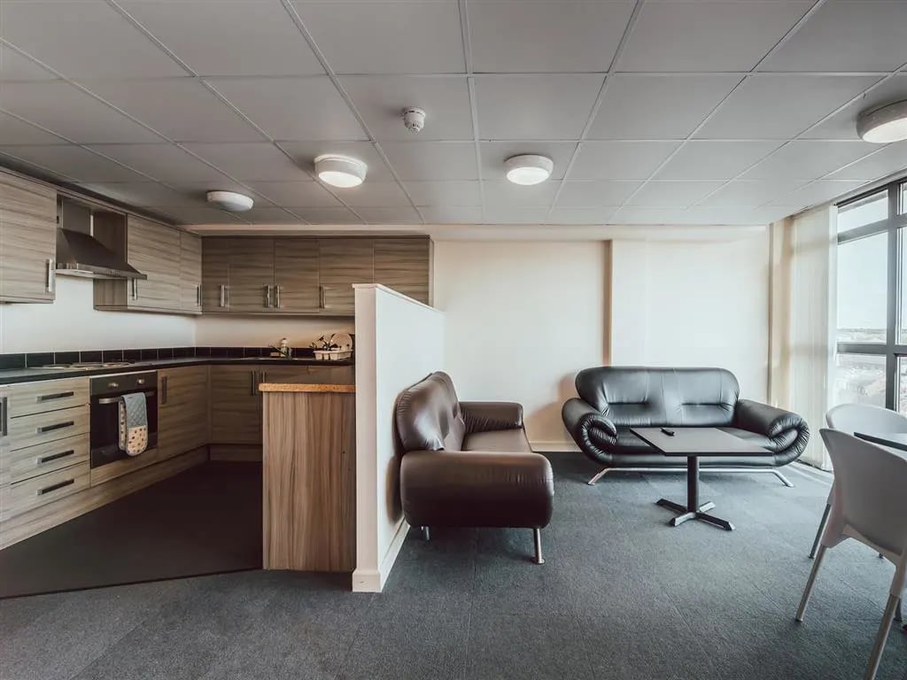 Kitchen and living area with sofas and table living room at Lomax Halls in Stoke-On-Trent Student Accommodation