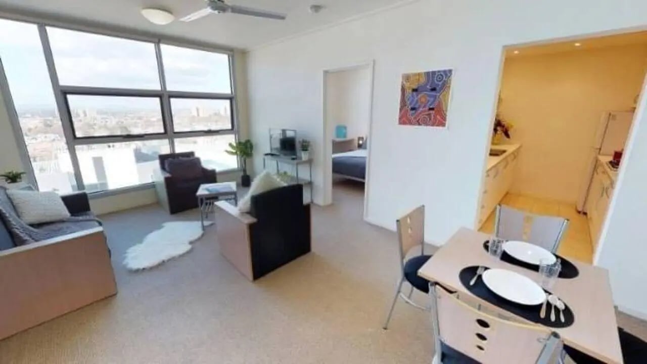 Sofa table chairs and kitchen living room at Student Living - 800 Swanston in Melbourne Student Accommodation