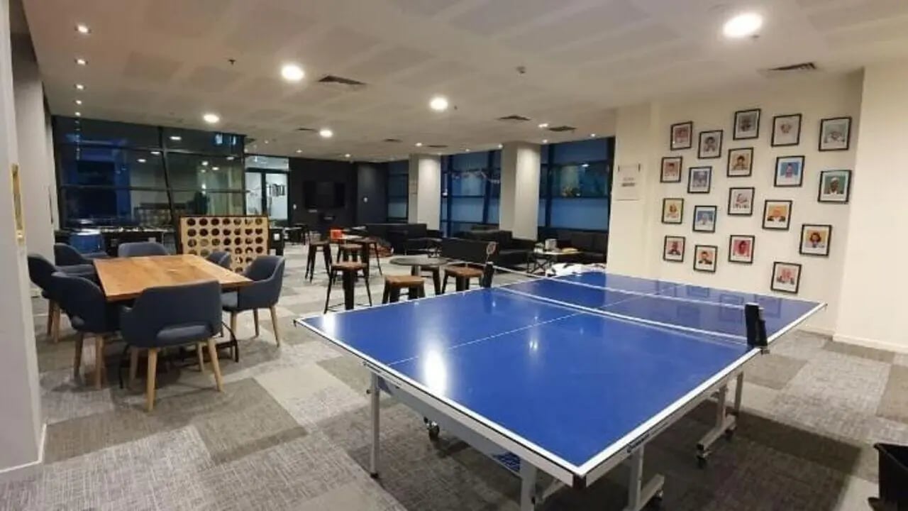 Ping pong table sofas and dining table living room at Student Living - 800 Swanston in Melbourne Student Accommodation