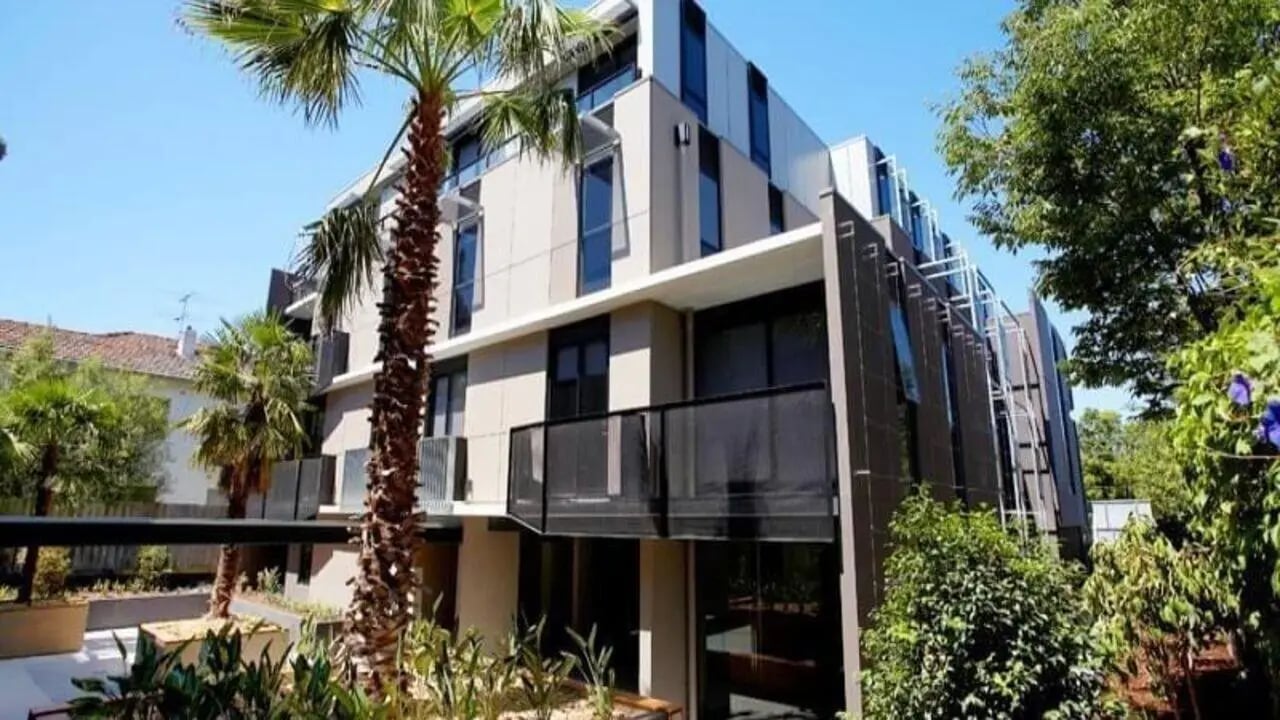 Modern building with balcony and palm trees exterior at Student Living on Riversdale in Melbourne Student Accommodation