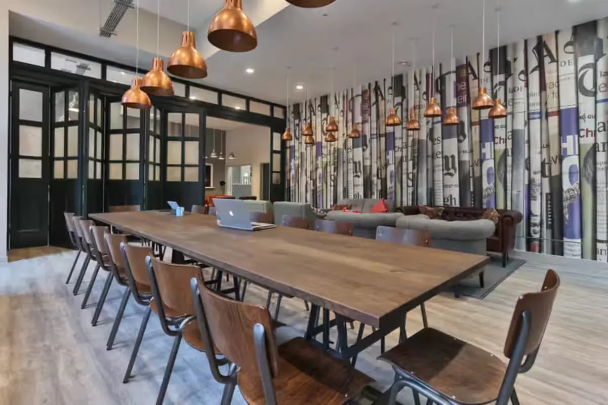 Long table with chairs laptop and couches communal living room at Willowbank in Glasgow Student Accommodation