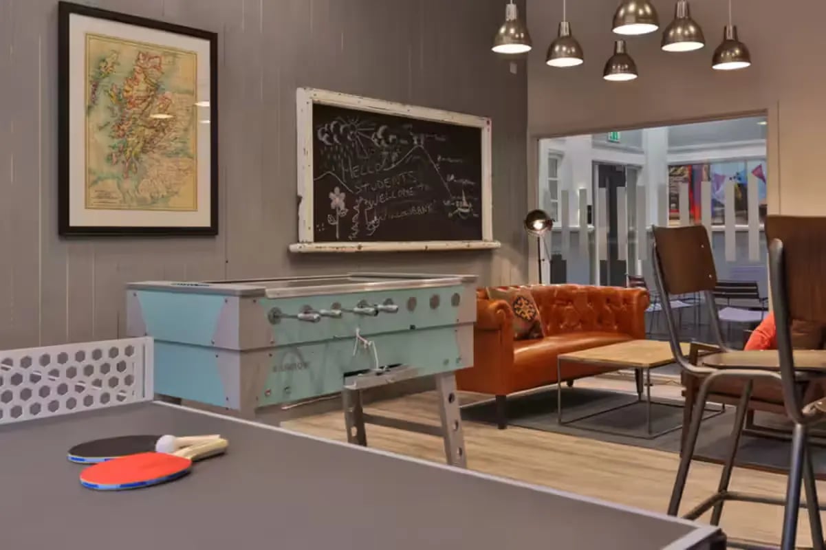 Ping pong table foosball table orange sofa living room at Willowbank in Glasgow Student Accommodation