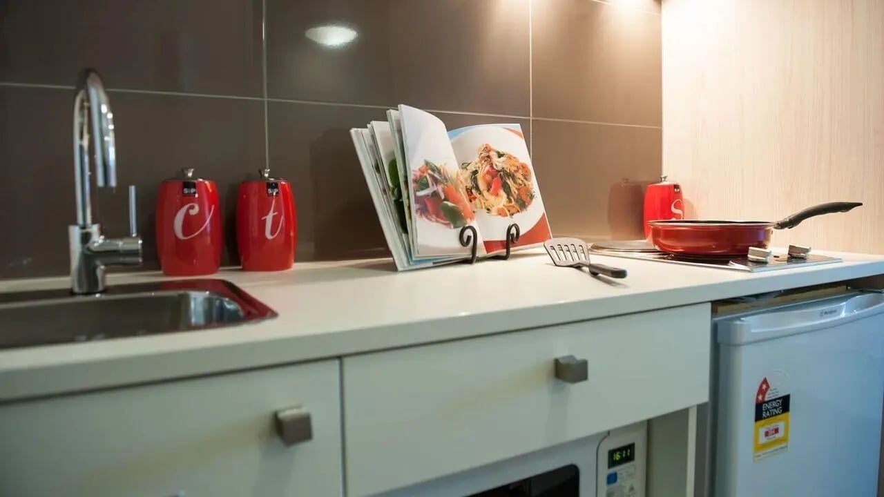 Sink spice jars cookbook frying pan kitchen at Student Living on Cobden in Melbourne Student Accommodation