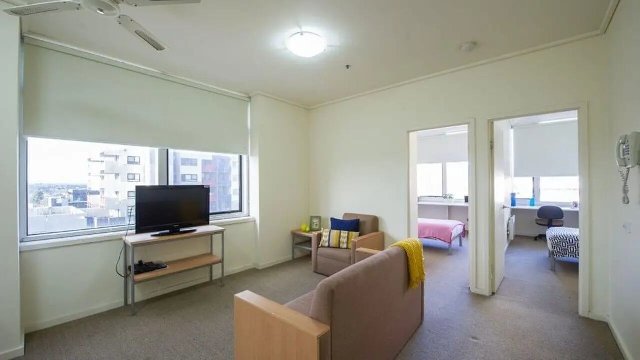 Sofa armchair television living room with bedrooms at Student Living - 550 Lygon in Melbourne Student Accommodation