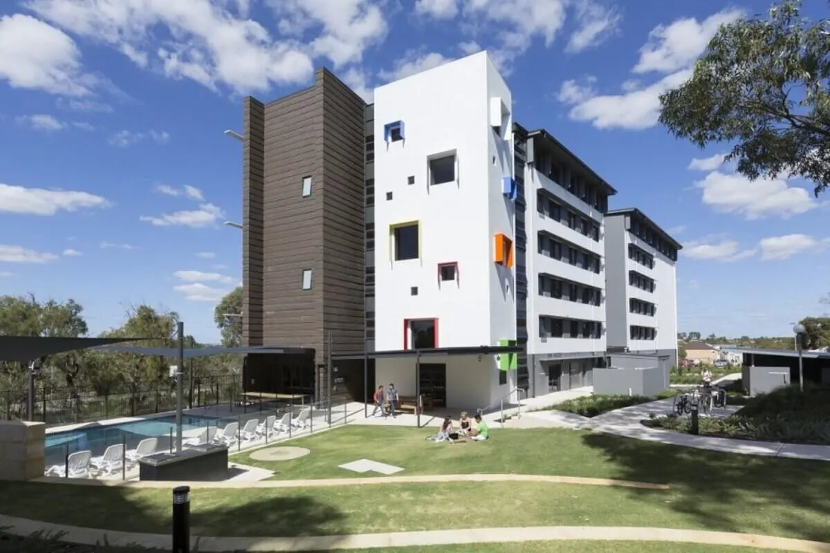 Modern student accommodation buildings pool chairs grass exterior at ECU Village Joondalup in Perth Student Accommodation