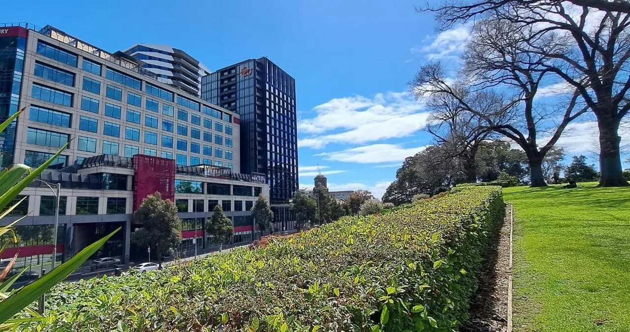 Apartment building with trees and park exterior at Iglu Flagstaff Gardens in Melbourne Student Accommodation