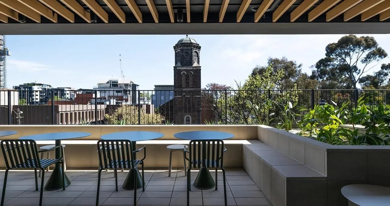 Blue tables and chairs on balcony outdoor area at Iglu Flagstaff Gardens in Melbourne Student Accommodation