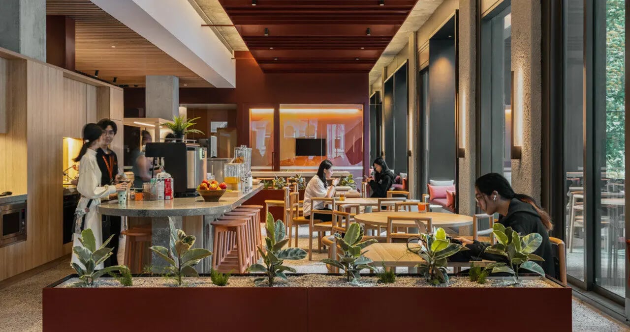 People and tables in communal kitchen lounge area at Iglu Melbourne Central in Melbourne Student Accommodation