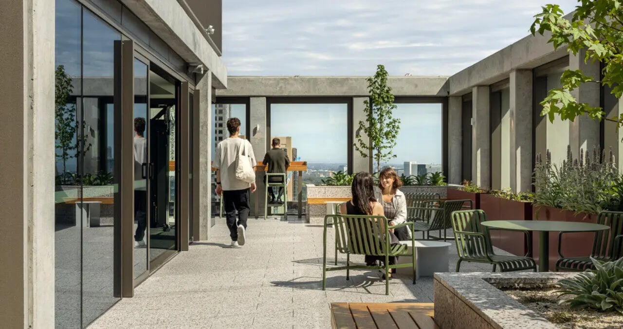 Outdoor lounge area with seating tables and plants at Iglu Melbourne Central in Melbourne Student Accommodation