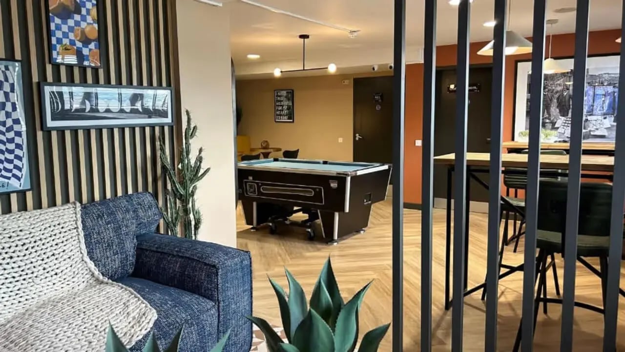 Blue sofa pool table and dining area common room at Northfield in Exeter Student Accommodation