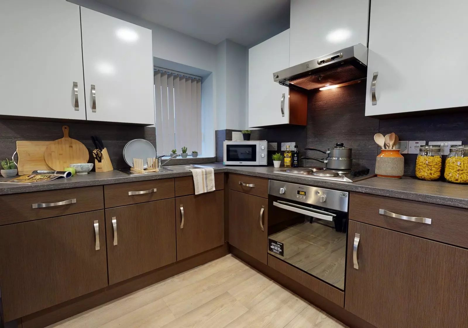 White and brown cabinets microwave oven hob kitchen at iQ Penworks House in Birmingham Student Accommodation
