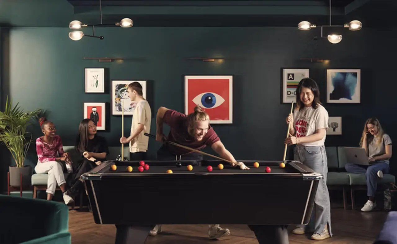 People playing billiards and relaxing communal room at The Plaza in Leeds Student Accommodation