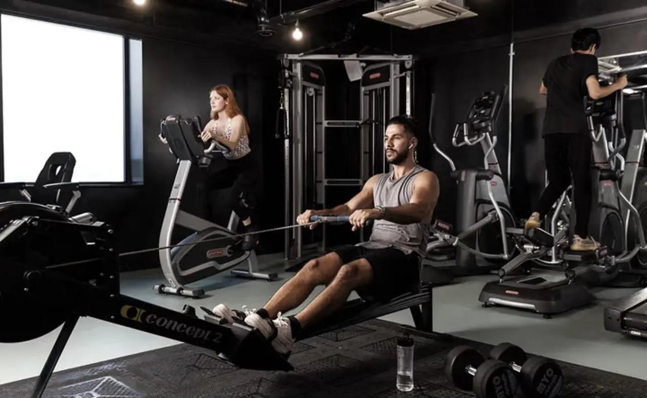 Gym with people using rowing elliptical and exercise bikes fitness area at The Plaza in Leeds Student Accommodation