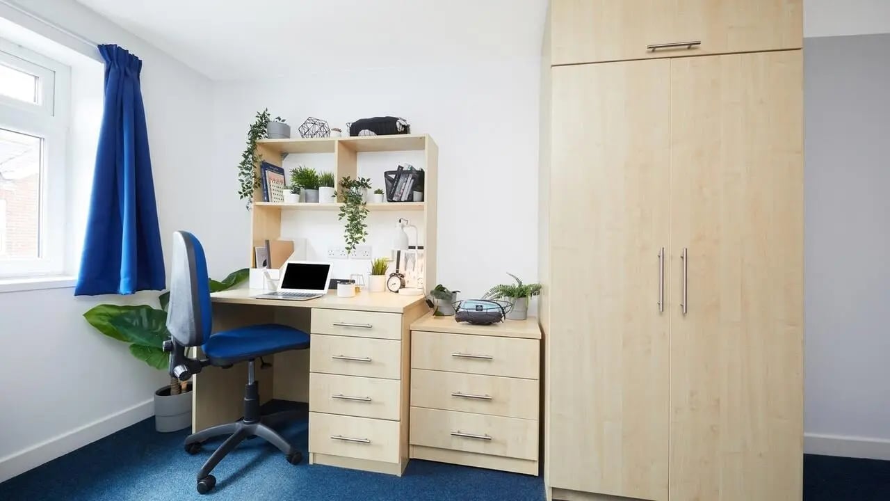 Desk chair shelves and wardrobe student room interior at Collegiate Bonhay House in Exeter Student Accommodation