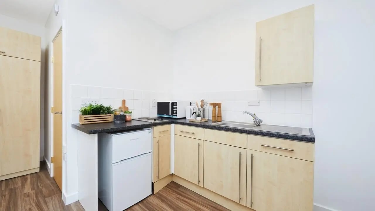 Kitchenette with microwave fridge sink and cabinets Kitchen at Collegiate Bonhay House in Exeter Student Accommodation