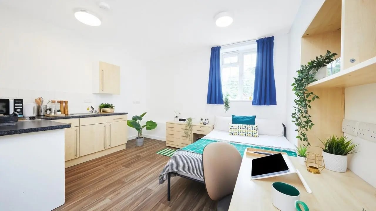 Bed desk kitchen and plants studio apartment at Collegiate Bonhay House in Exeter Student Accommodation