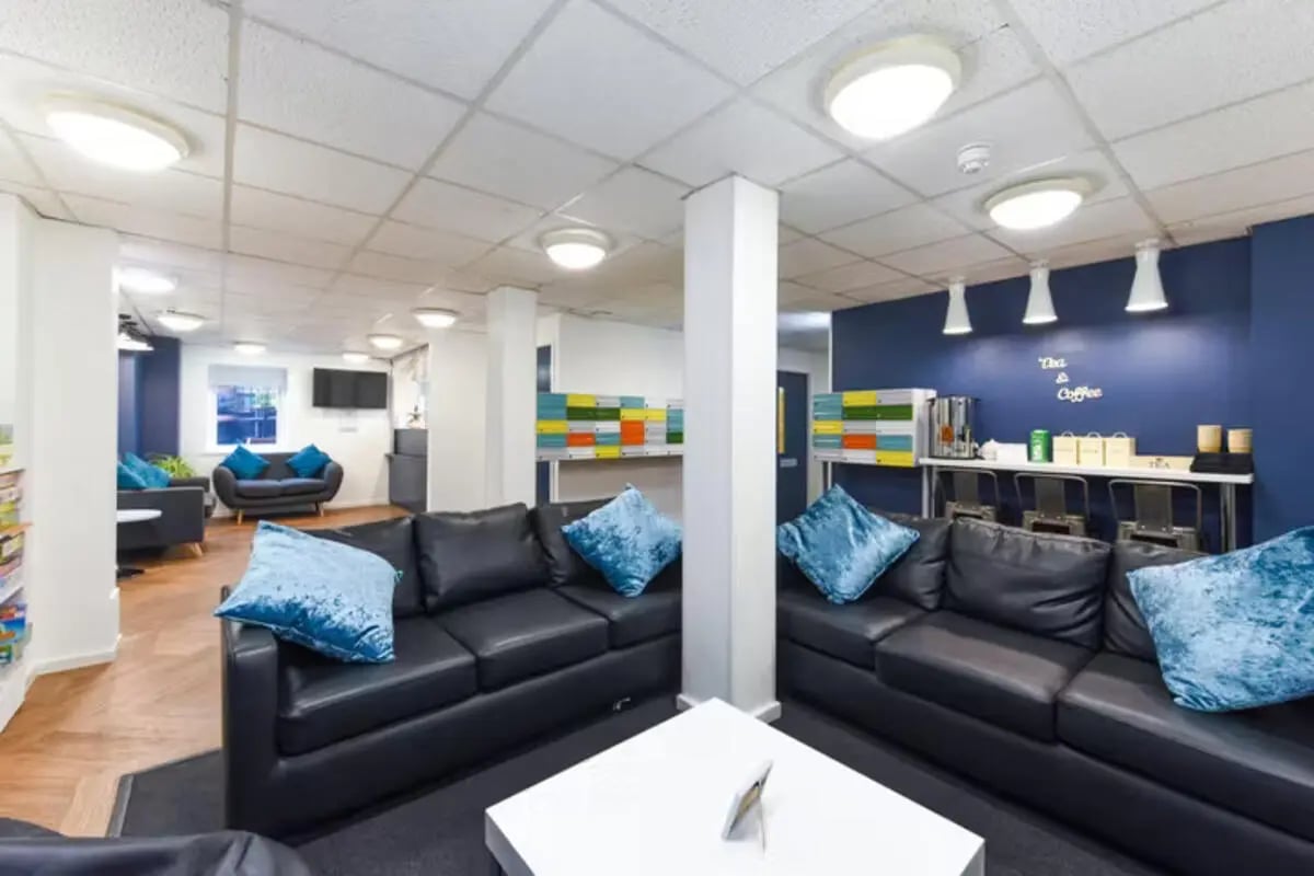 Black sofas blue cushions white coffee table living room at Apollo Court in Liverpool Student Accommodation