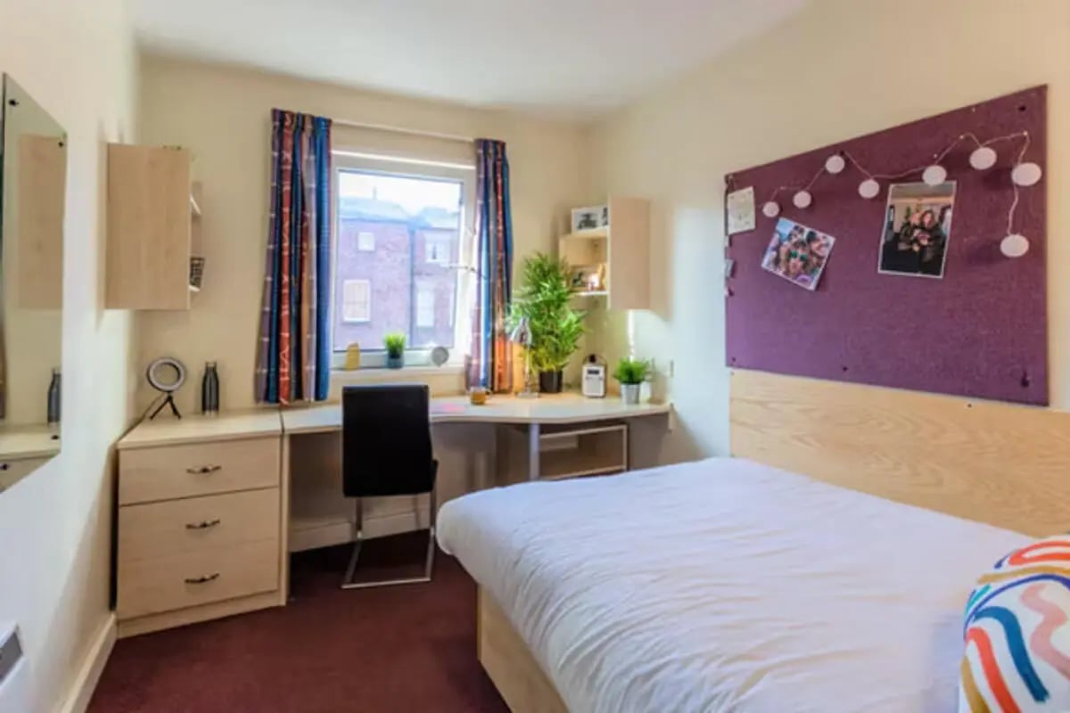 Bed desk chair corkboard photos string lights bedroom at Apollo Court in Liverpool Student Accommodation