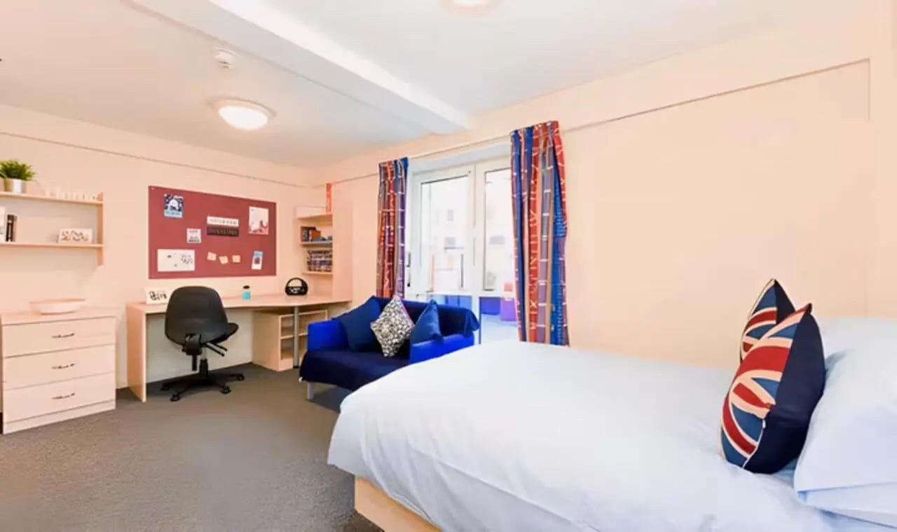 Bed desk chair blue sofa bedroom at Apollo Court in Liverpool Student Accommodation