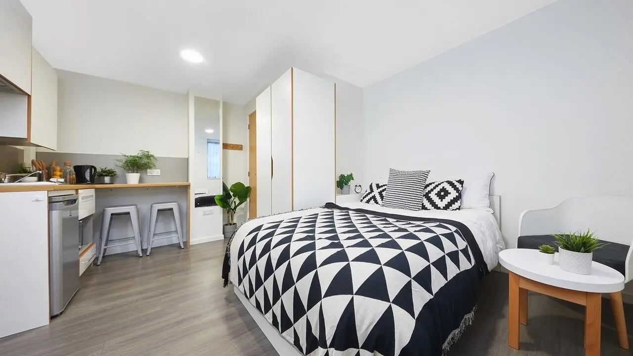 Bed kitchen counter and stools bedroom at Collegiate Merlin Heights in Leicester Student Accommodation