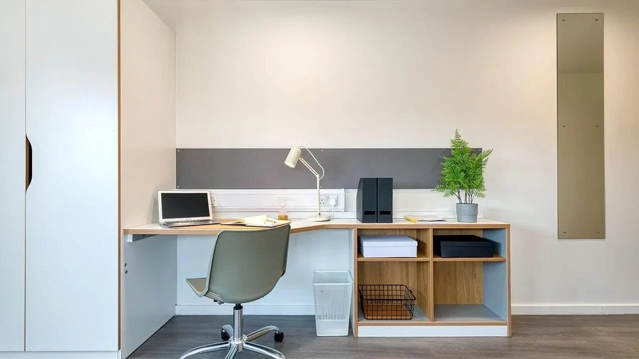 Desk with laptop chair lamp and shelf Study area at Collegiate Merlin Heights in Leicester Student Accommodation