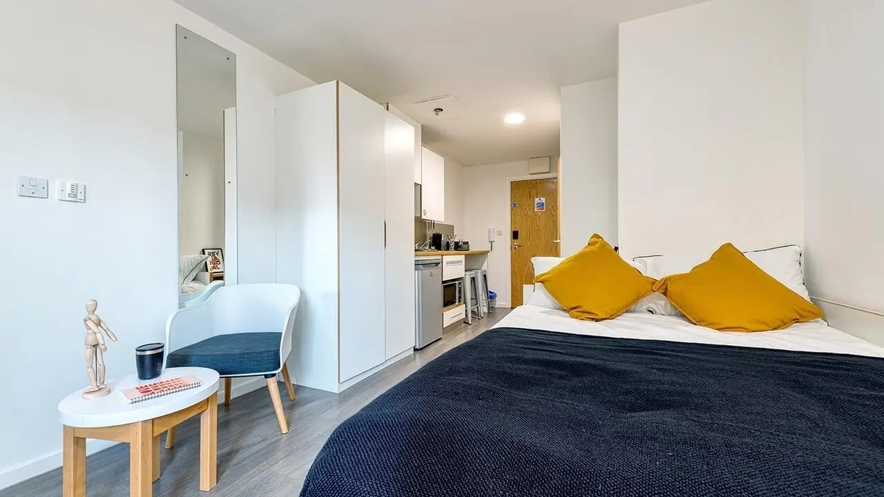 Bed chair desk area kitchen studio apartment at Collegiate Merlin Heights in Leicester Student Accommodation