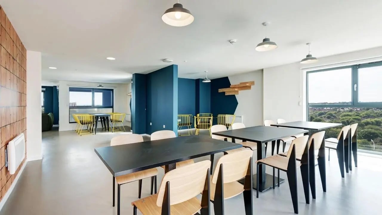 Black tables wooden chairs communal area living room at Collegiate Merlin Heights in Leicester Student Accommodation