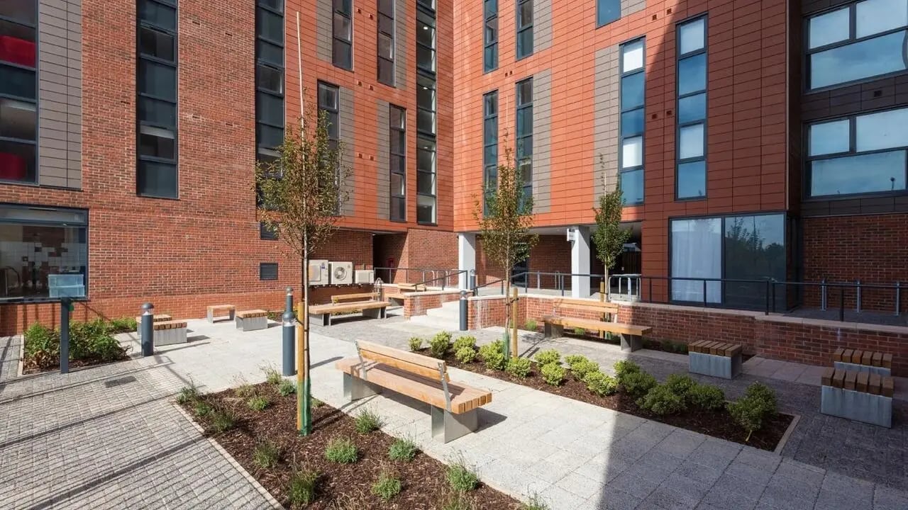Benches and trees in a courtyard exterior at Collegiate Merlin Heights in Leicester Student Accommodation