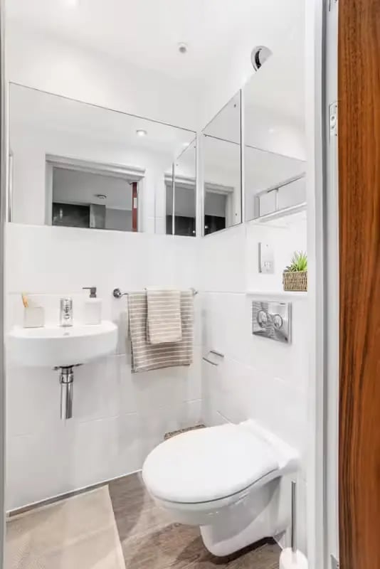 Toilet sink towels mirror and plant bathroom at Windsor House in Cardiff Student Accommodation