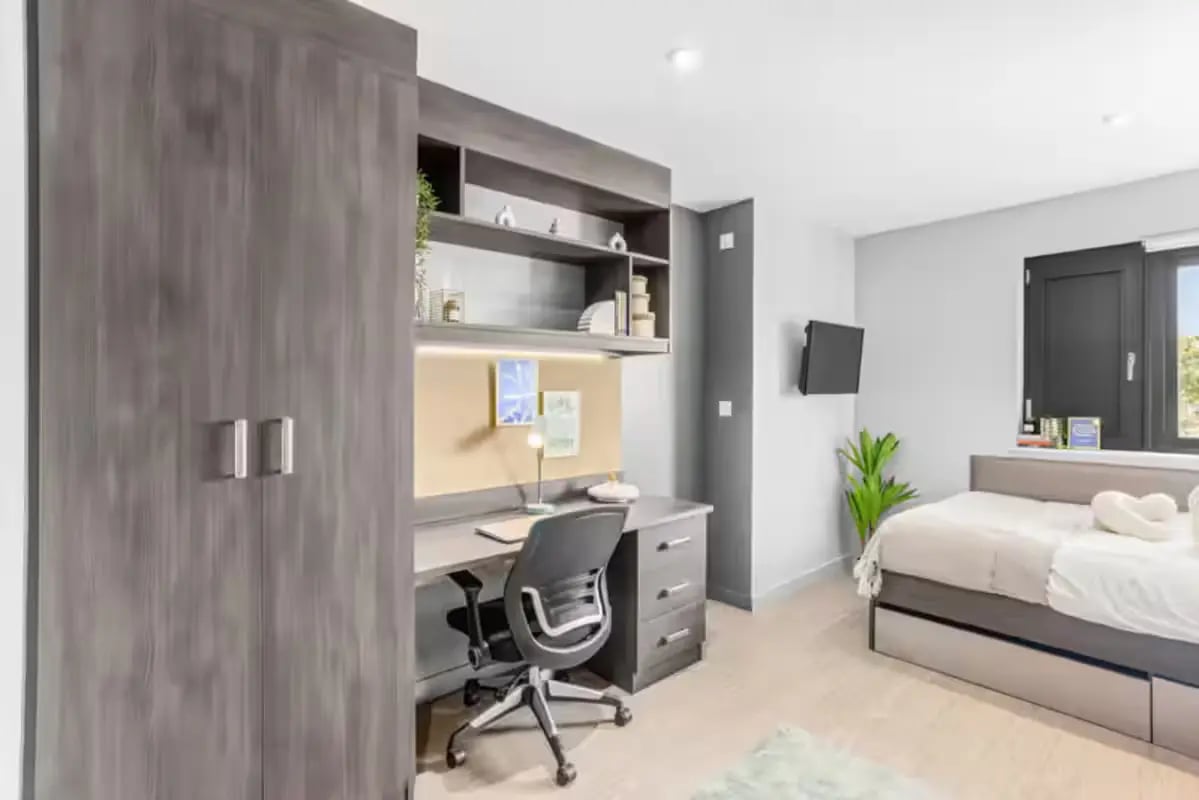 Wardrobe desk chair bed and television bedroom at Windsor House in Cardiff Student Accommodation