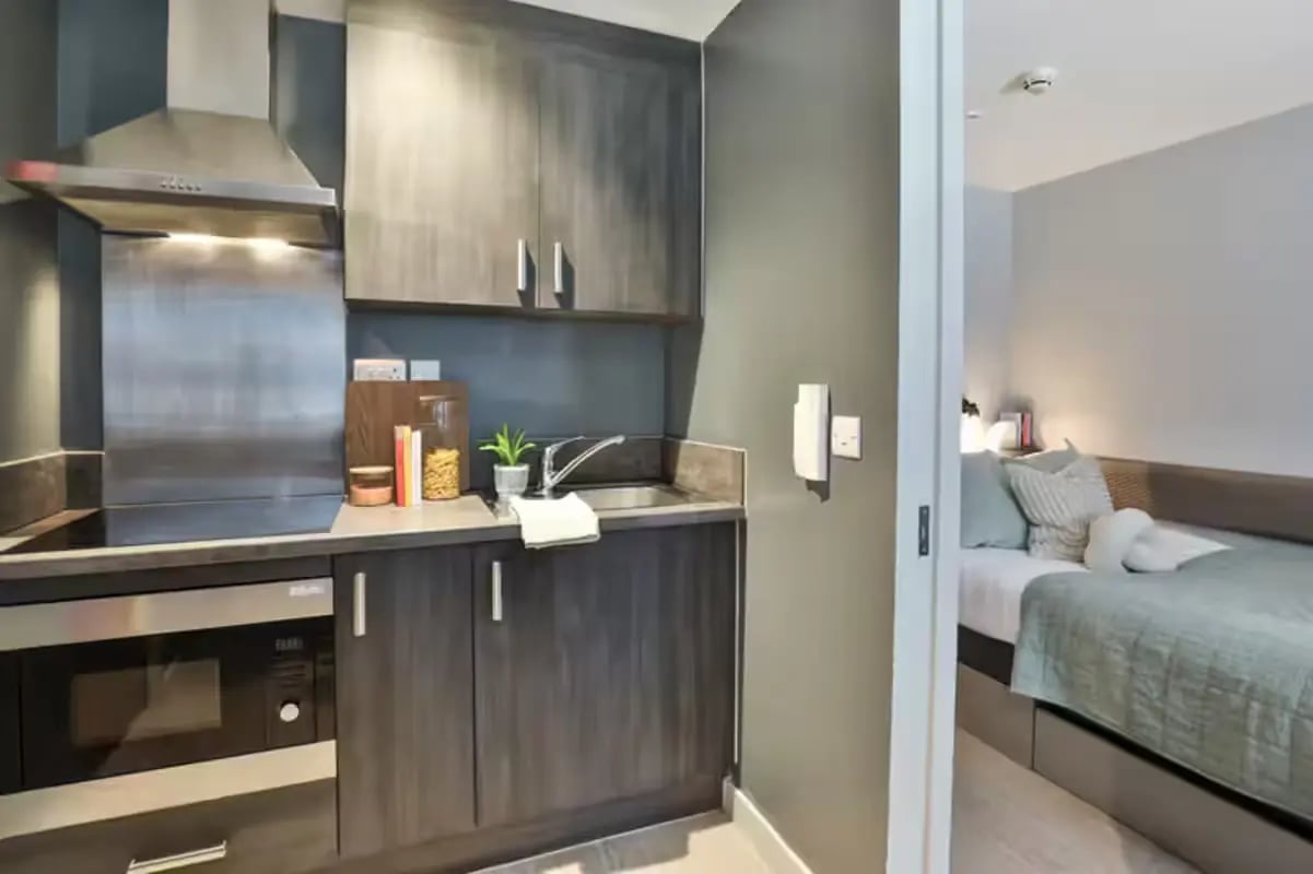 Compact kitchen with microwave and bed bedroom at Windsor House in Cardiff Student Accommodation