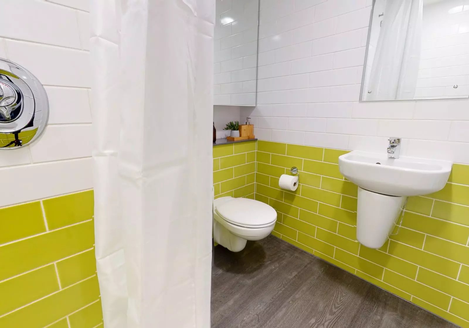 Toilet sink shower curtain and shower controls bathroom at iQ Aldgate in London Student Accommodation