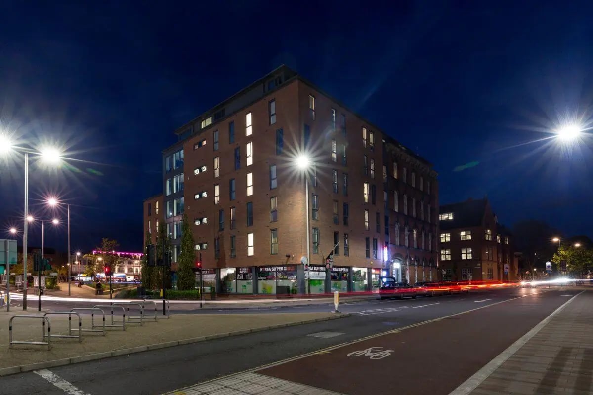 Brick student accommodation building exterior at night at Applegate Place in Leicester Student Accommodation