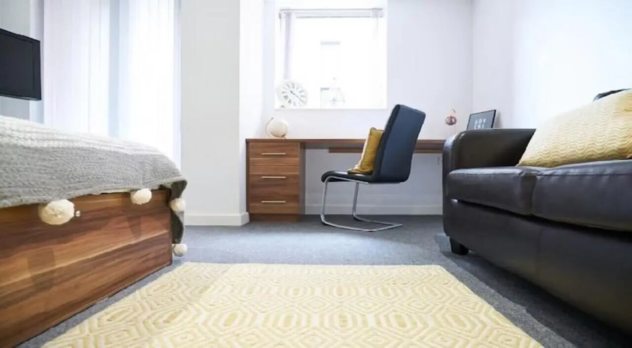 Bed sofa desk chair and rug bedroom at Windsor Court in Liverpool Student Accommodation
