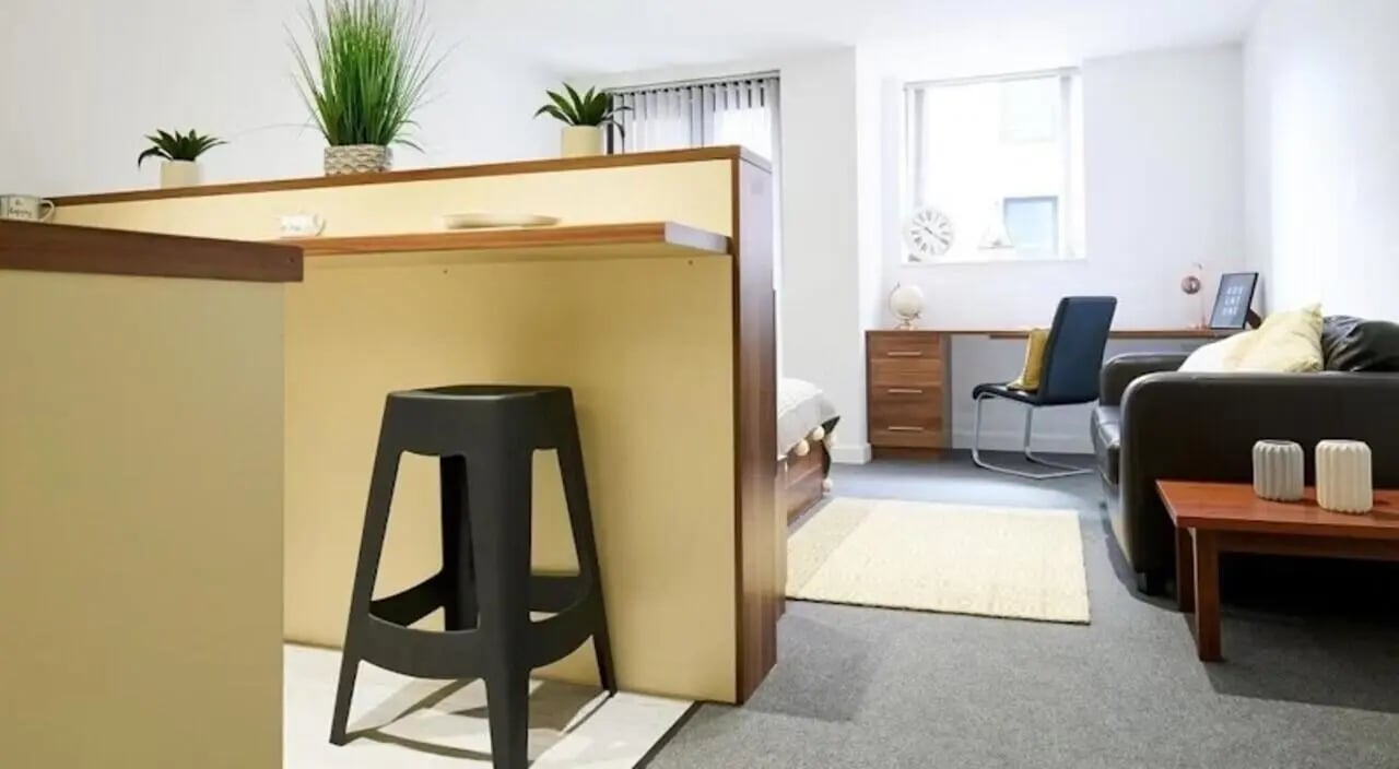 Bar stool desk couch bed and plants studio apartment at Windsor Court in Liverpool Student Accommodation