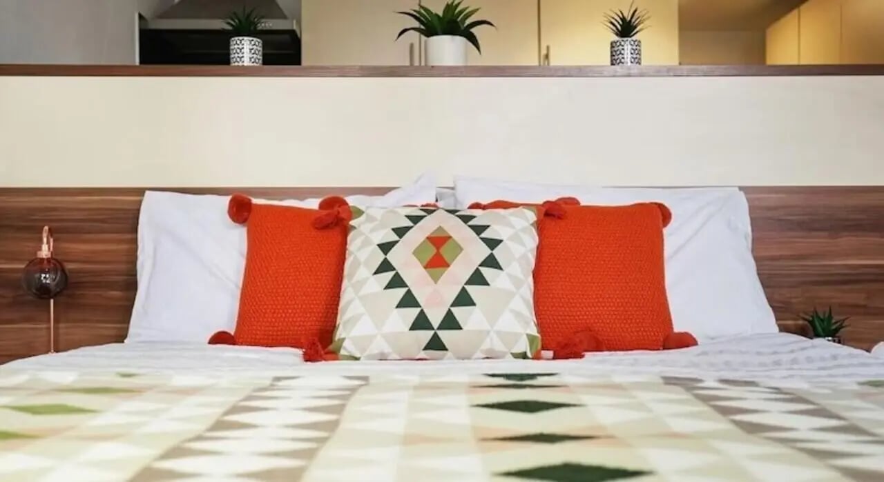Bed with orange and patterned pillows Bedroom at Windsor Court in Liverpool Student Accommodation